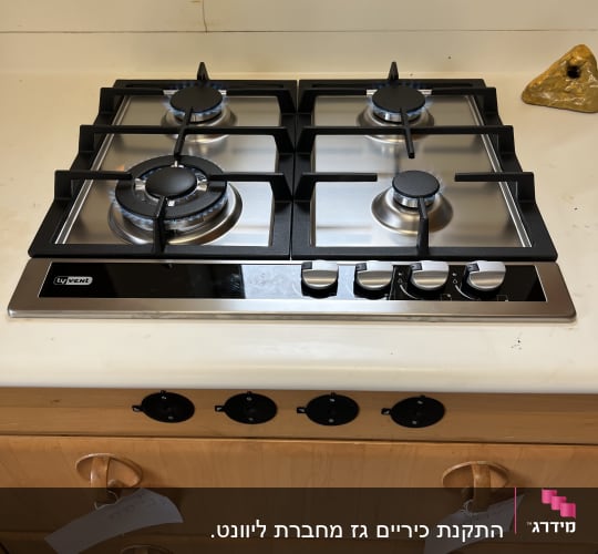 כיריים גז עם ארבעה מבערים על משטח מטבח